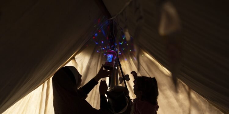 A Gaza family uprooted by war and grieving their losses shares a somber Ramadan meal in a tent